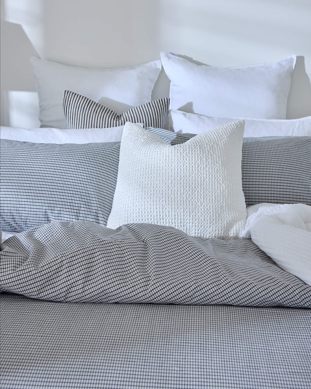 Royal Doulton Kent duvet cover styled on a bed with coordinating Wade duvet cover set, Winslow Snow Cushion, Montrose Stripe Cushion, Beaumont Check Cushion.