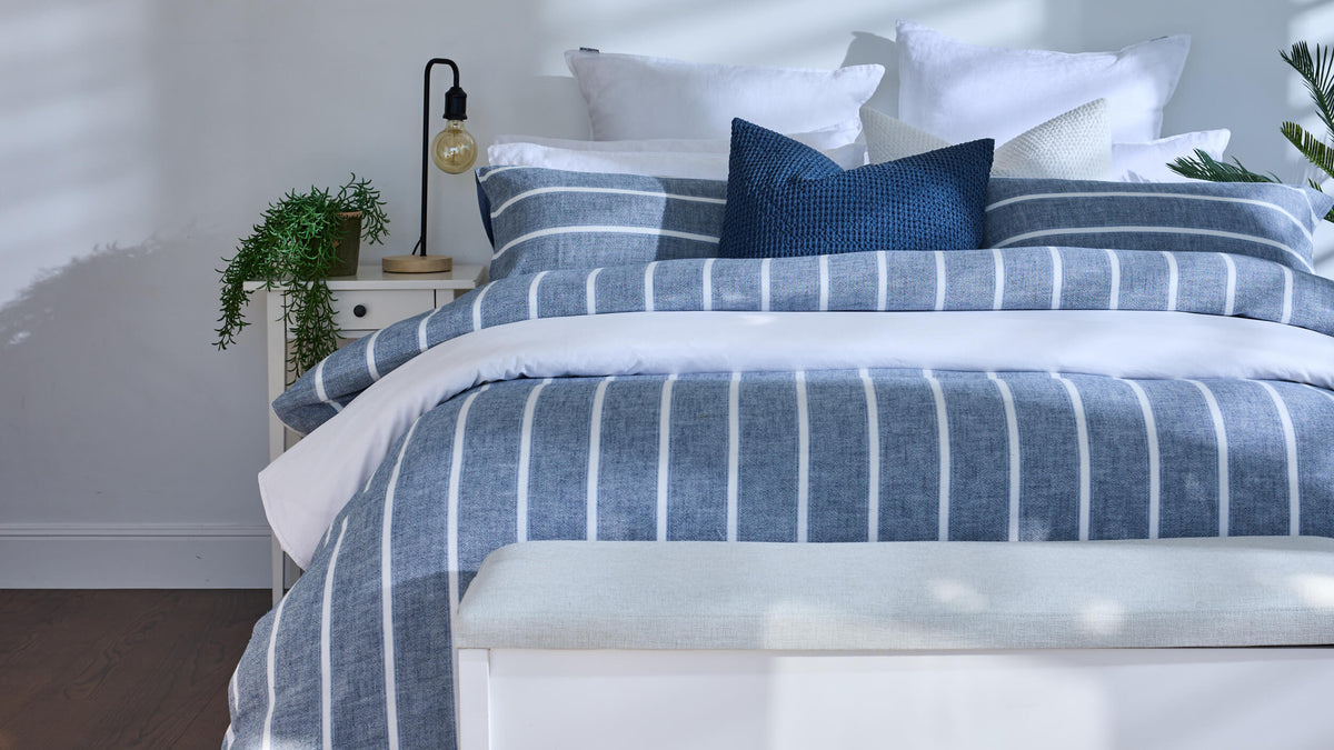 Royal Doulton Kate Nelson blue striped duvet cover on a bed with a navy cushion