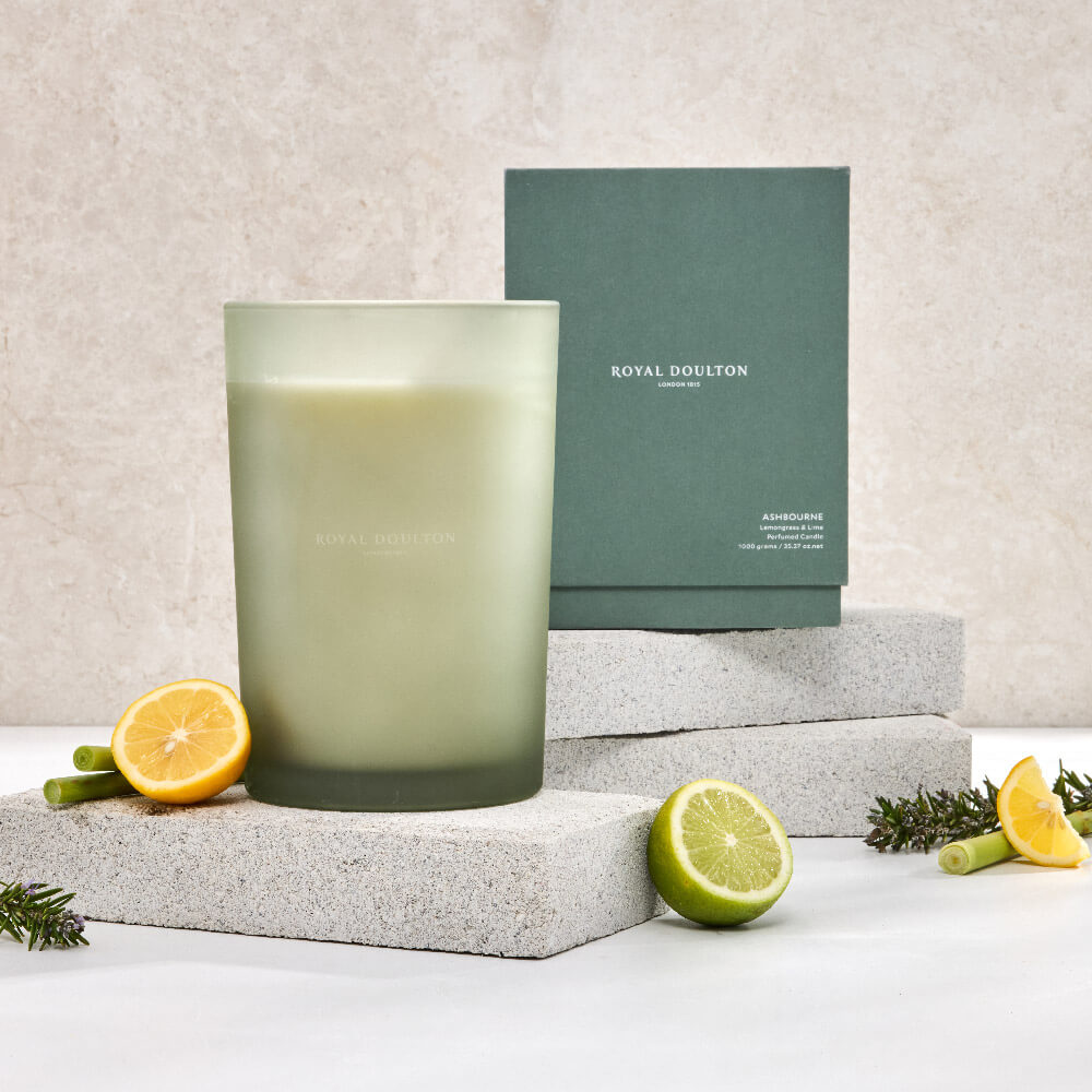 Royal Doulton Ashbourne 1000g candle in a tall green vessel with its packaging box, citrus fruit and pale display blocks.