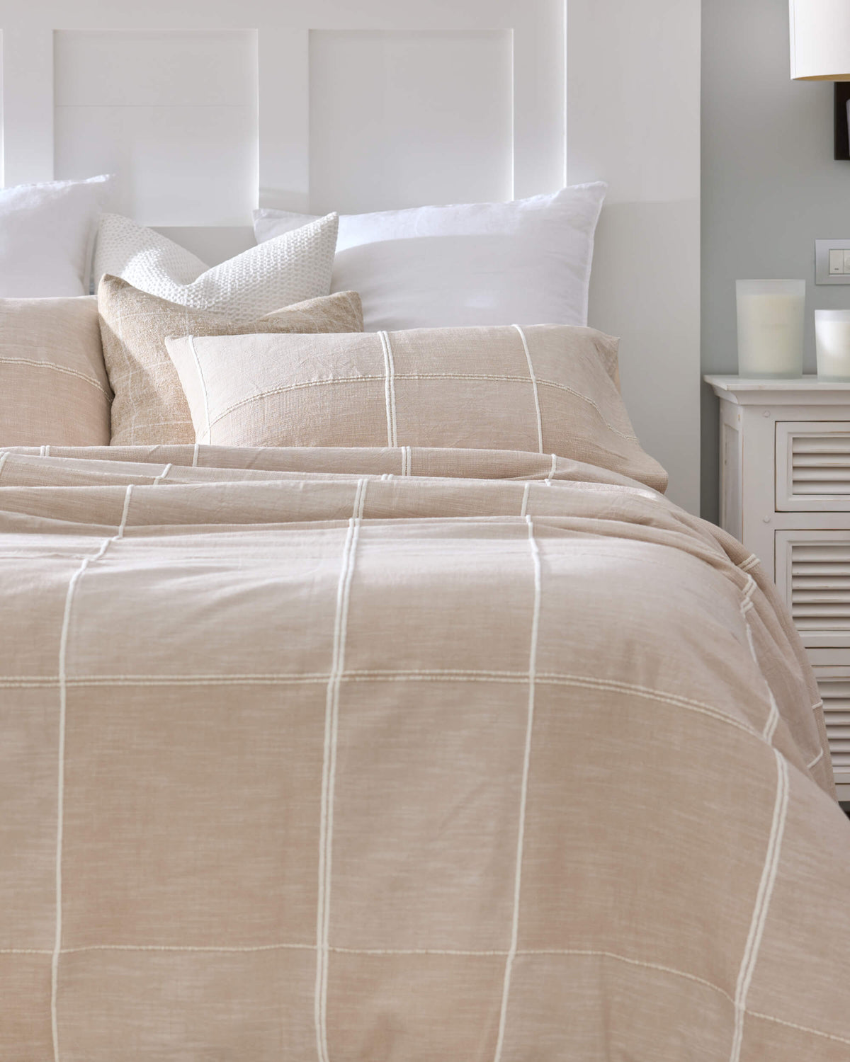 Royal Doulton Whitby neutral grid bedding styled with layered white and textured pillows