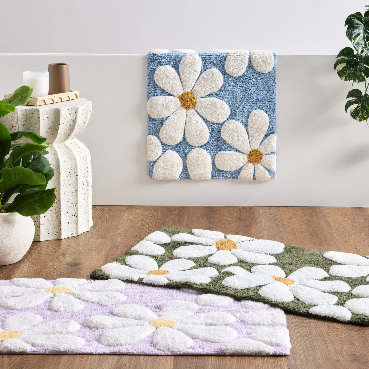 June & Jupiter Daisy bath mats in blue, green and lilac with raised white flowers and yellow centres