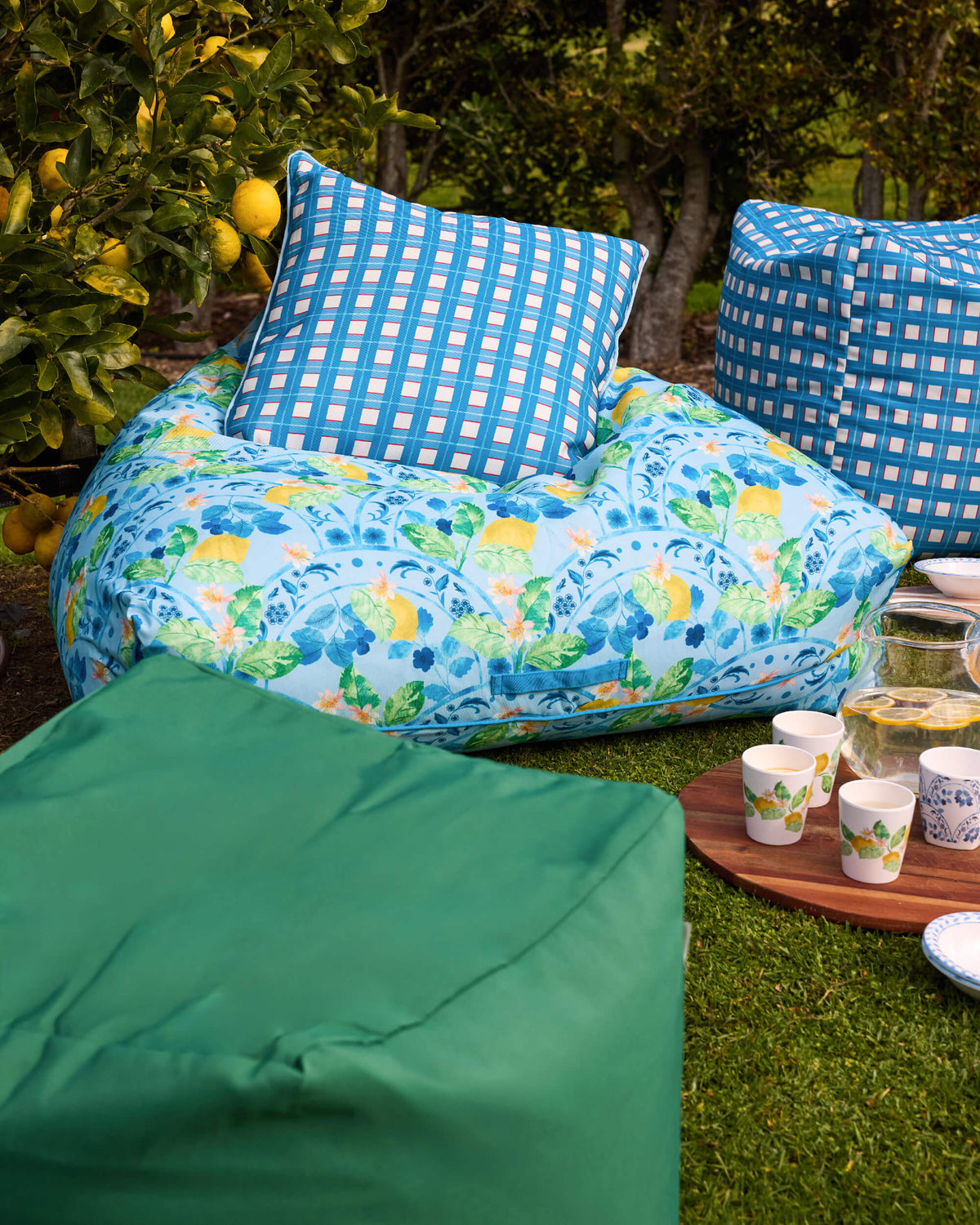 Twill & Co lemon-patterned bean bag with a blue checked cushion beside green and checked outdoor seating