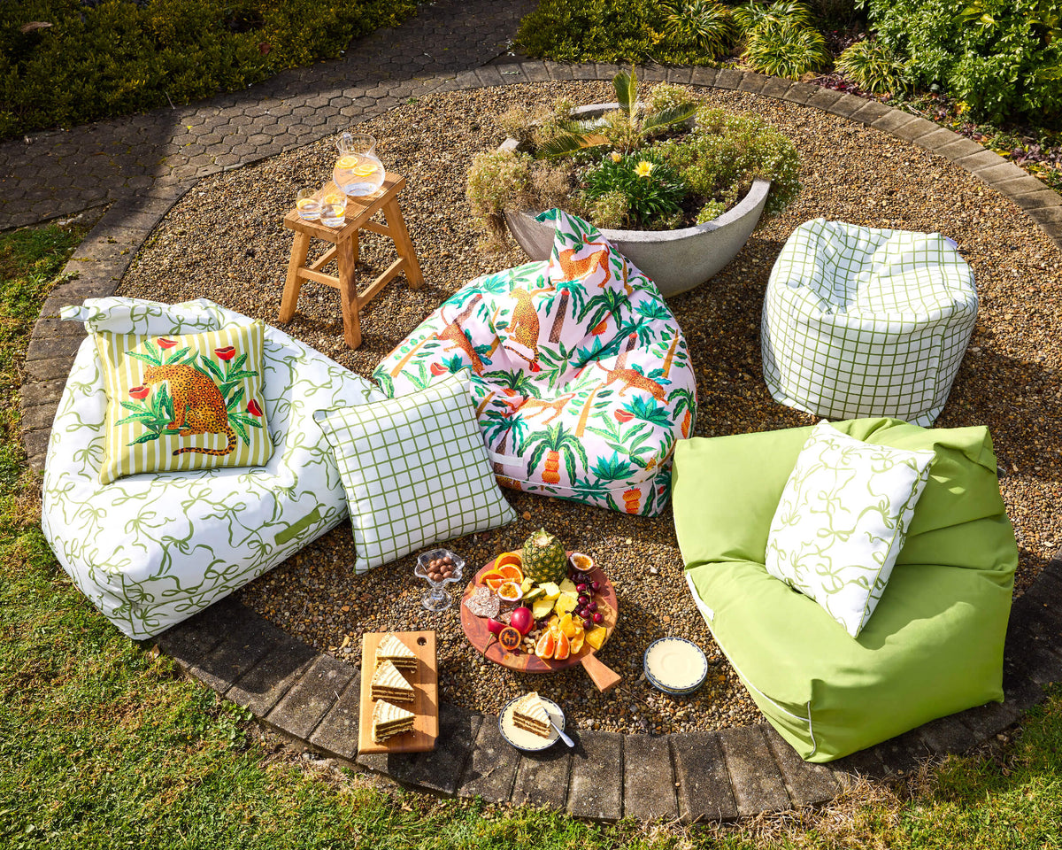Wide overhead view of Twill & Co Tigerlily seating arranged around picnic food on a circular garden patio