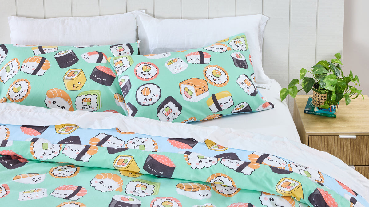Twill & Co cartoon sushi bedding in mint green and blue styled on a bed