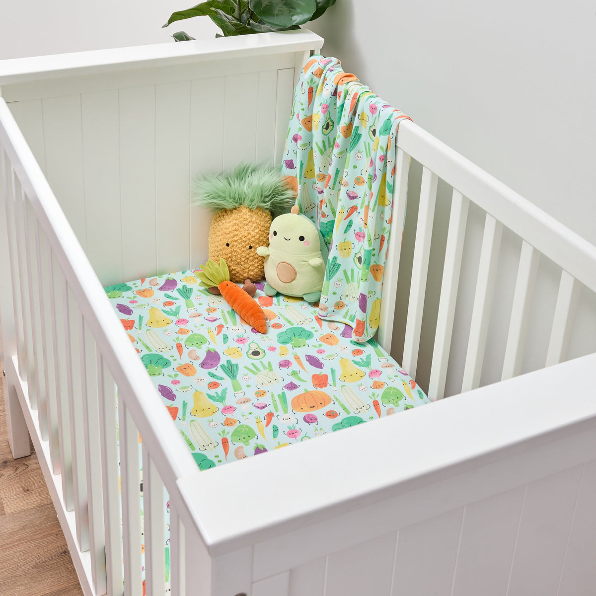 Twill and Co nursery bedding in a white cot with colourful vegetable characters