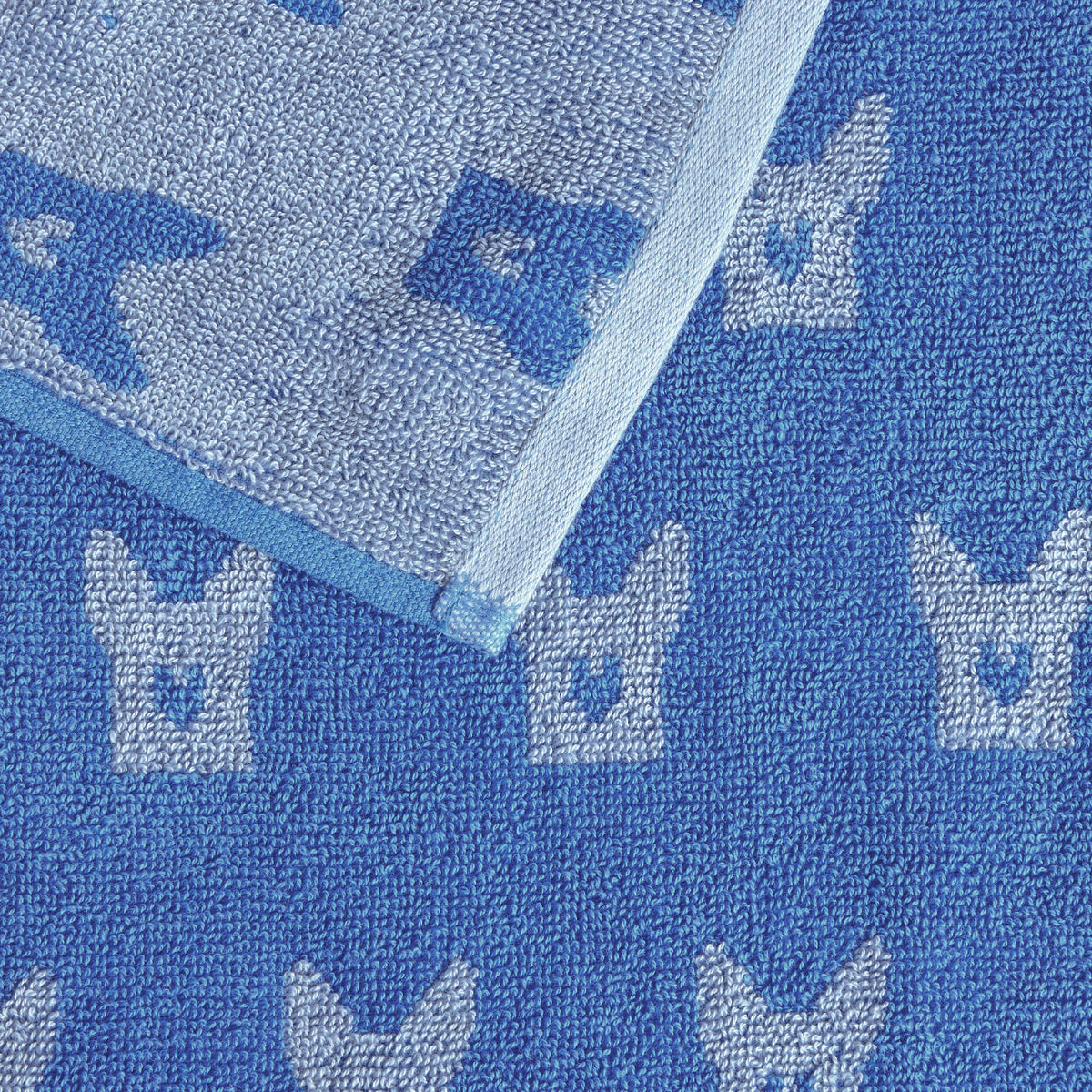 Close-up of a blue Twill & Co dog towel folded back to show its contrasting reverse