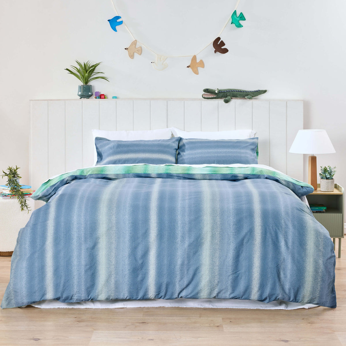 Twill & Co blue striped kids bedding with a green reverse beneath a bird garland