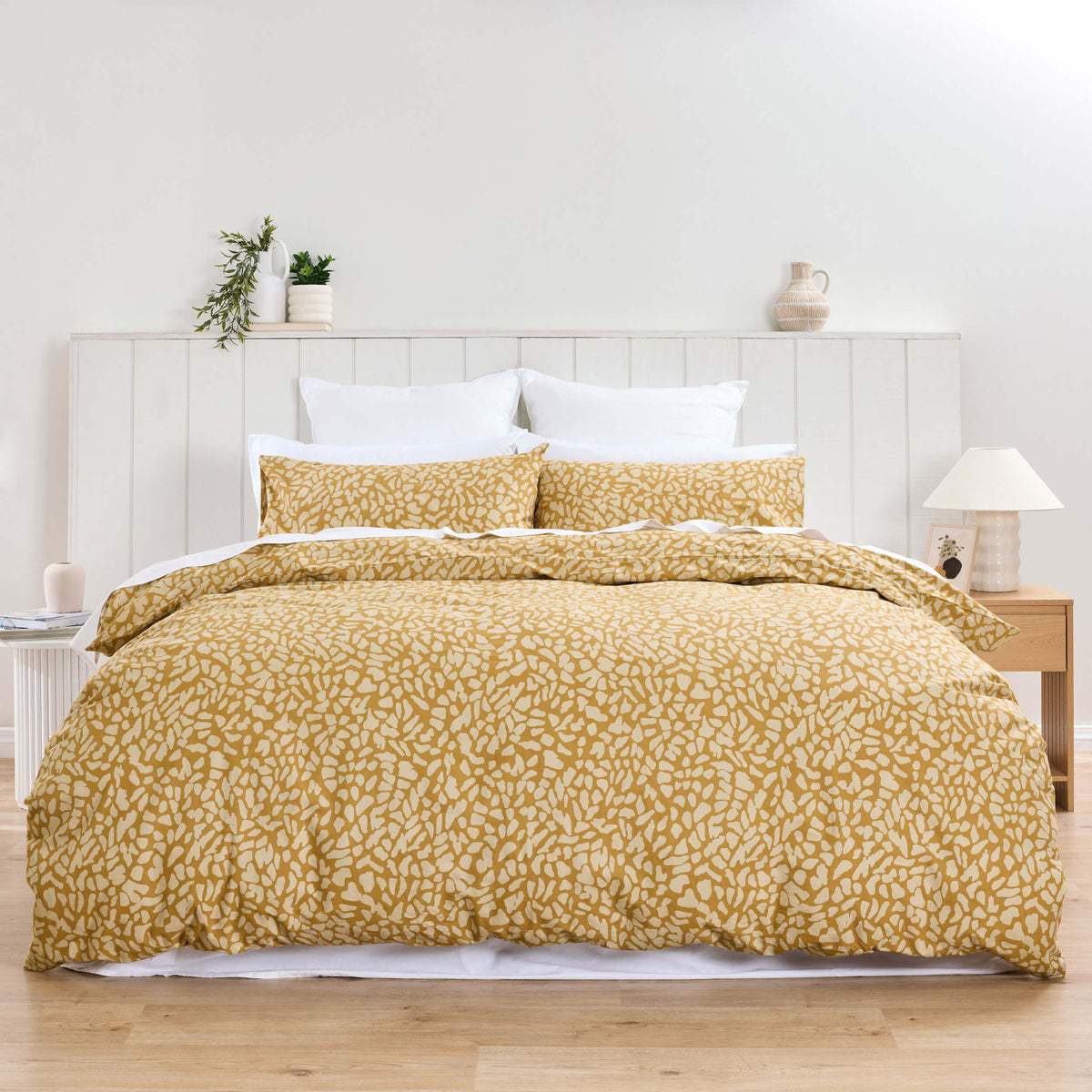 Twill & Co Maj mustard duvet cover with a small cream leaf pattern, shown from the foot of the bed