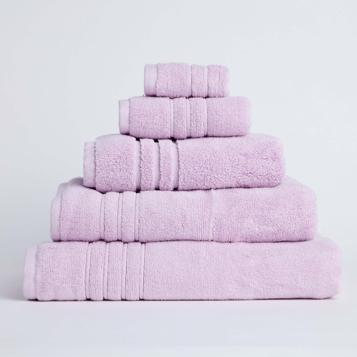Folded pink Twill & Co Sora Peony towels arranged in a graduated stack