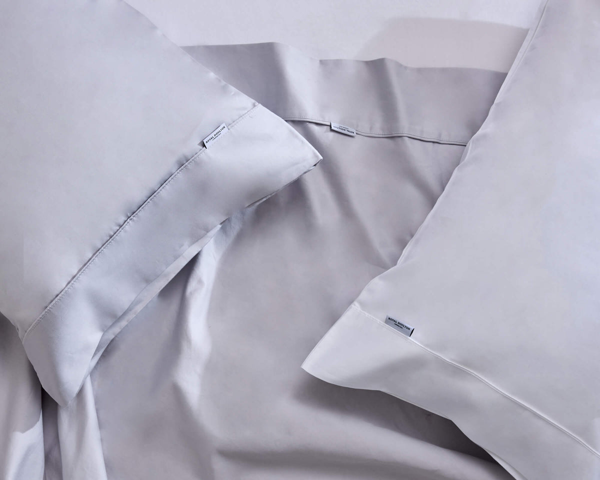 Royal Doulton Aria pale grey sheet set and pillowcases arranged on a bed