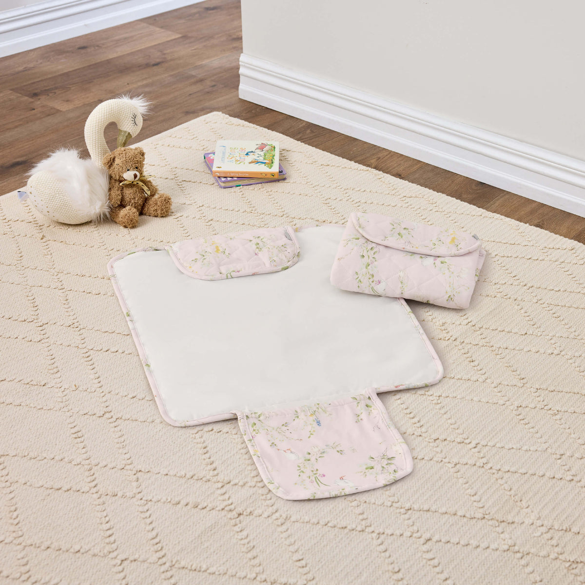 Twill & Co floral change mat shown open beside a folded mat on a cream rug