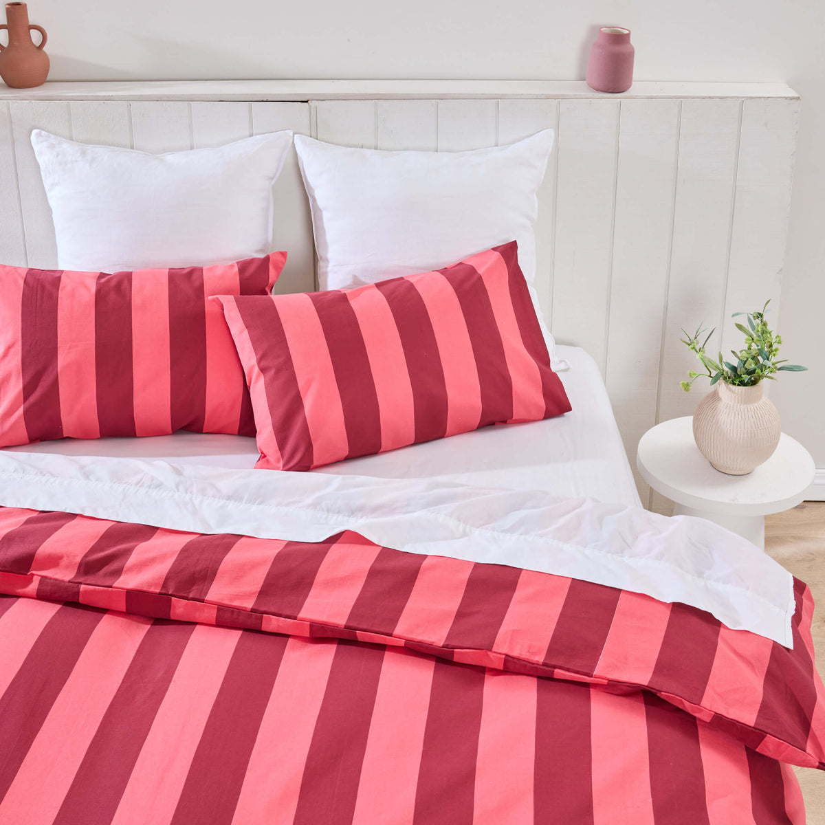 Twill & Co Cabana duvet cover and pillowcases with bold red and pink stripes on a white bed