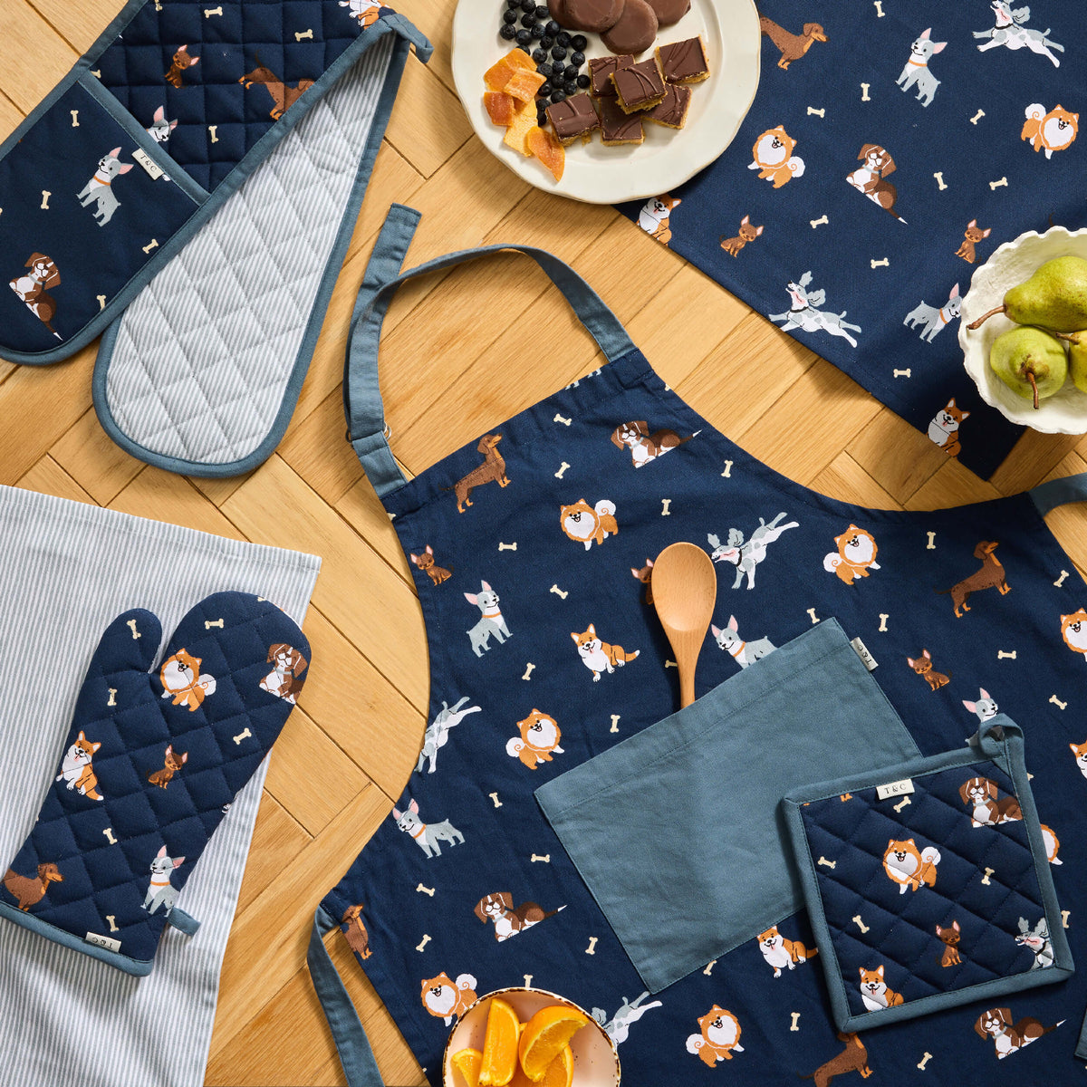 Navy Twill & Co Happy Hounds apron and quilted kitchen gloves with dog prints and blue-grey trim