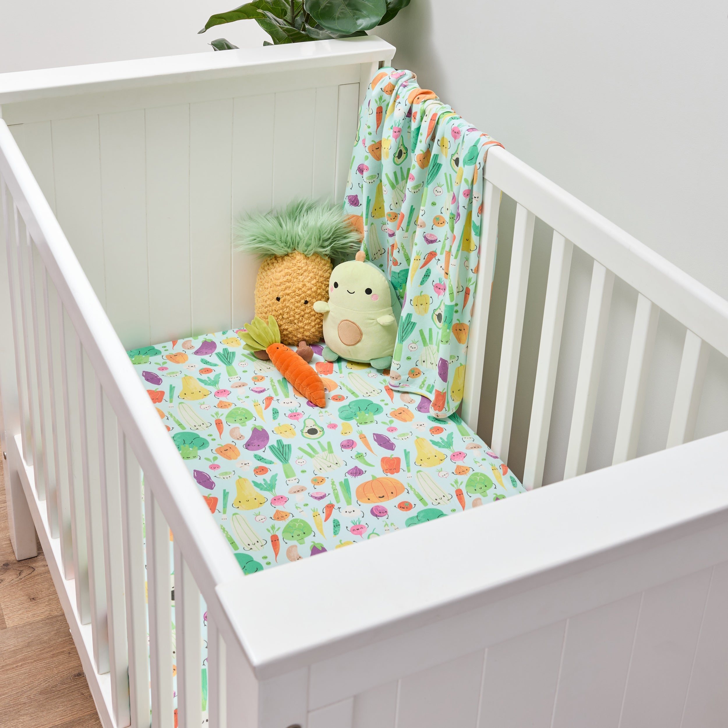 Twill and Co nursery bedding in a white cot with colourful vegetable characters