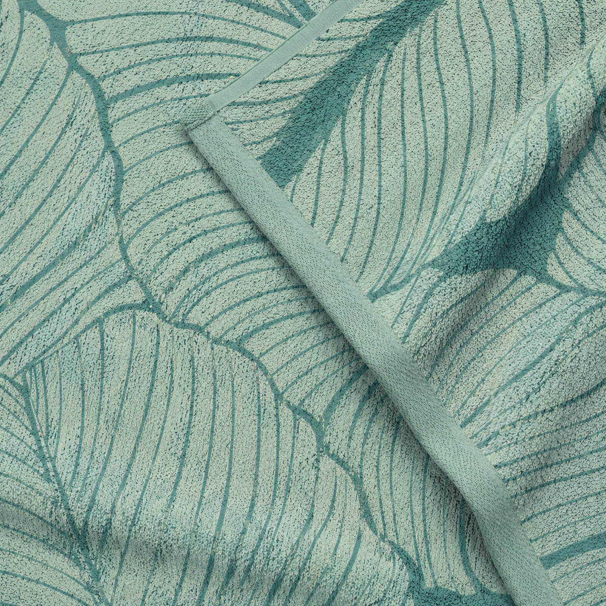 Close-up of the green leaf outlines and bound edge of a Twill & Co Tropical Time towel