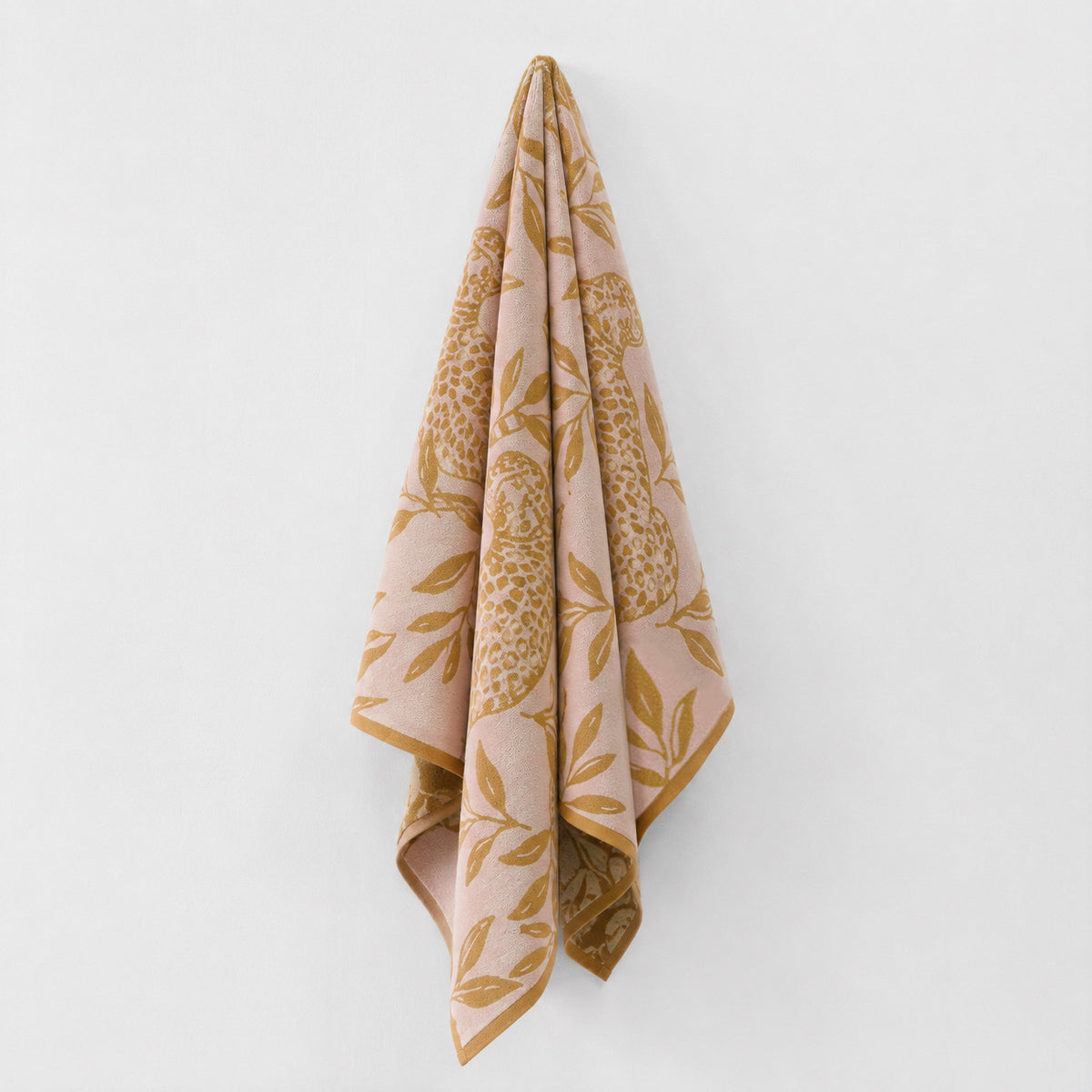 Twill & Co Wild Thing beach towel hanging in pink and ochre with a leaf and leopard print