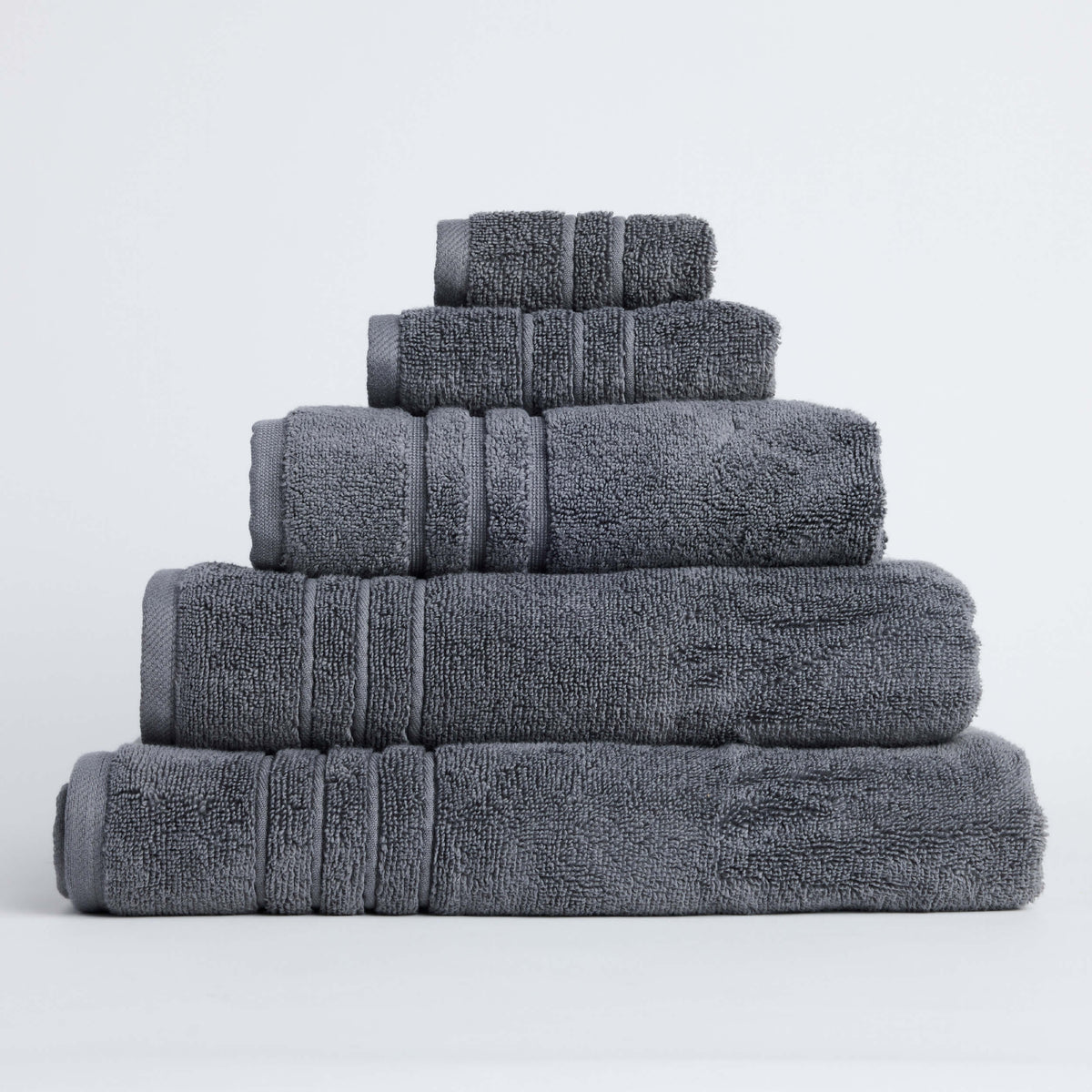 Twill & Co Sora Coal towels stacked from largest to smallest, showing charcoal fabric and striped borders